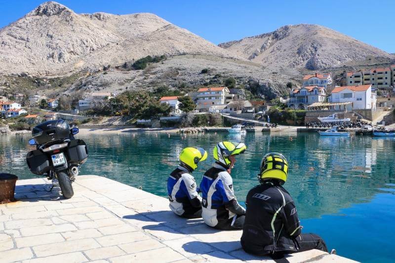 Motorcyclists take a break at a Balkan lake